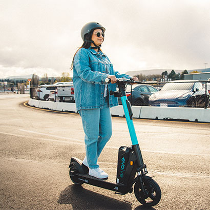 Young woman driving Evo Evolve E-scooter