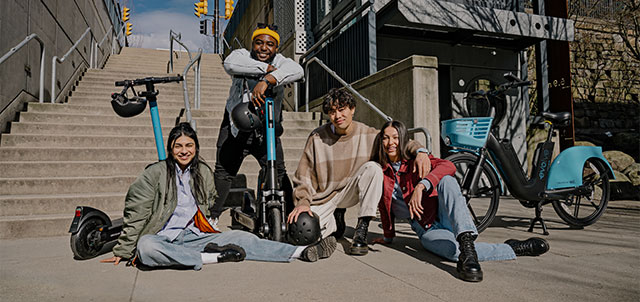 Group of friends sitting and chatting while Evo scooters parked on the side